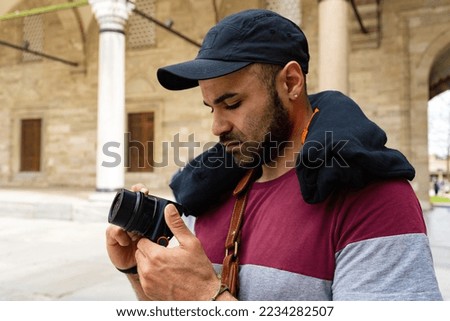 Young man photographer takes photographs with camera in a city of Istanbul