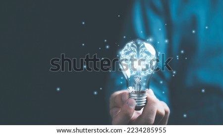 Businessman hand holding lightbulb with glowing virtual brain and  connection line to creative smart thinking for inspiration and innovation with network concept. Royalty-Free Stock Photo #2234285955