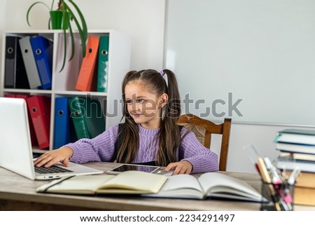 Portrait of a beautiful girl in the classroom at a desk with books and a computer. the concept of learning. school. school time