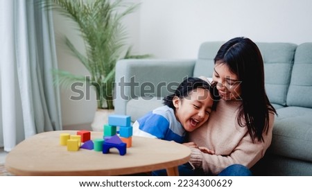 Happy Latin american mother and son having fun playing together at home - Family and love concept - Soft focus on mom face.