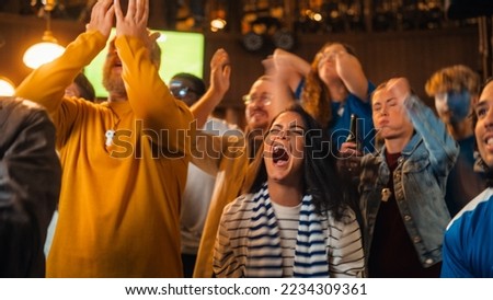 Group of Diverse Soccer Fans Cheering Their Team During a Football Game Live Broadcast in a Sports Pub. Anxious Crowd Saddened and Angry When Competitor Player Scores a Decisive Goal. Royalty-Free Stock Photo #2234309361