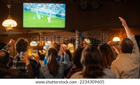 Soccer Club Members Cheering for Their Team, Playing in an International Cup Final. Supportive Fans Standing in a Bar, Cheering, Raising Hands and Shouting. Friends Celebrate Victory After the Goal. Royalty-Free Stock Photo #2234309605