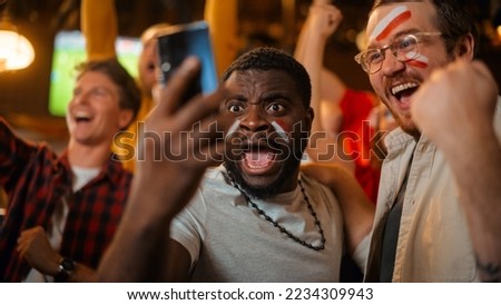 Portrait of Two Excited Diverse Friends Holding a Smartphone, Celebrate Winning a Sports Bet on Their Favorite Soccer Team. Lively Successful Emotions When Football Team Scores a Winning Goal. Royalty-Free Stock Photo #2234309943