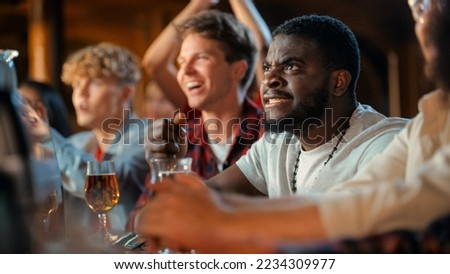 Nervous African Man Watching a Live Soccer Match on TV in a Sports Bar. Excited Fans Cheering and Shouting. Young Black Male Stress Out for His Team at Football World Cup. Royalty-Free Stock Photo #2234309977