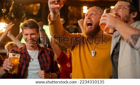 Group of Soccer Fans Watching a Live Football Match in a Sports Bar. Three Male Friends Standing in Front of a TV, Toasting Beer Glasses and Celebrate The Goal and the Championship Win. Royalty-Free Stock Photo #2234310135