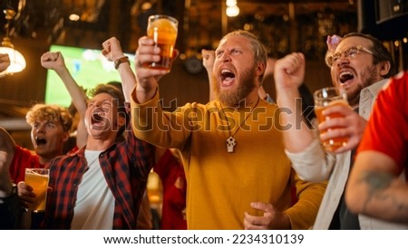 Soccer Club Members Cheering for Their Team, Drinking Beer in a Pub. Supportive Fans Standing in a Bar, Cheering, Raising Glasses and Shouting. Friends Celebrate Victory After the Goal. Royalty-Free Stock Photo #2234310139
