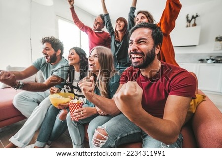 Happy friends watching soccer world cup on television at home Royalty-Free Stock Photo #2234311991