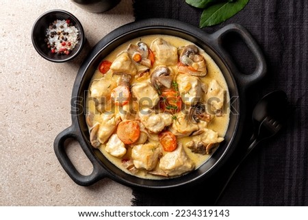 Top view of Blanquette de poulet, is a French chicken stew with carrots, mushrooms, onion. Simmered in a white stock and served in a sauce enriched with cream, herbs. 