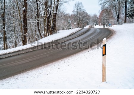 Driving in winter road conditions.Scenic view of empty road with snow covered landscape. Adverse weather conditions.