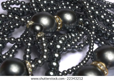 Black necklace with the big and small beads on a white background