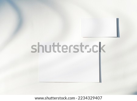 Blank business card mockup with shade of natural leaves shadow overlay on white background, for product or presentation