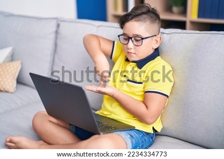 Adorable hispanic boy having video call communicate with sign deaf language at home
