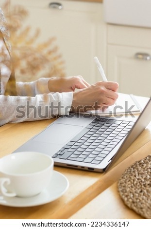 Close up of hand holding pen to write on textbook file, working from home on business project. Person using notebook to take notes and writing information on paper. Remote work at desk