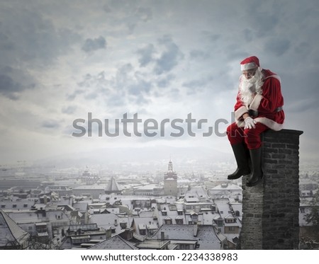 sad santa claus sitting on a chimney of a building