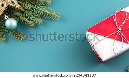 Christmas background design concept, holiday decoration ornament composition with Christmas tree branch, gift box with copy space isolated on green table.