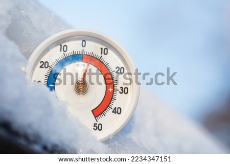 Thermometer with celsius scale in the snow showing plus 5 degree ambient temperature. Unusually high winter conditions. Warm winter weather and climate change concept Royalty-Free Stock Photo #2234347151
