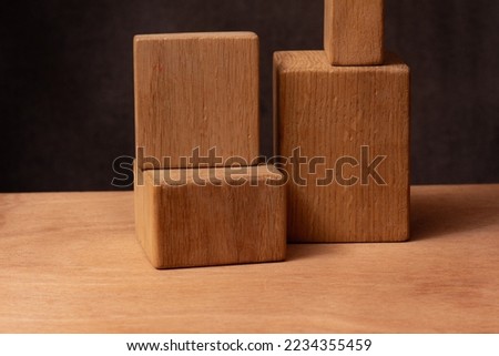 photogpaphy of a Parallelepiped wooden figures - still life on a wooden table on dark blurred background