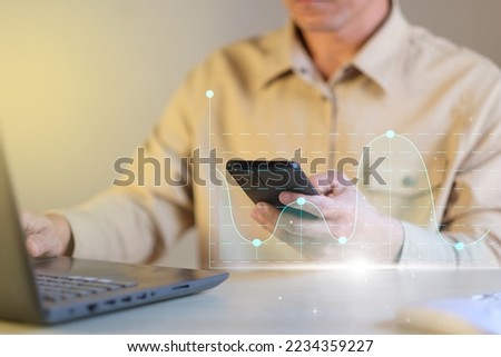 Businessman examines sales data and an economic growth graph chart on his smartphone. Strategy and business planning Exchange trading analysis Banking financial report Digital marketing technology