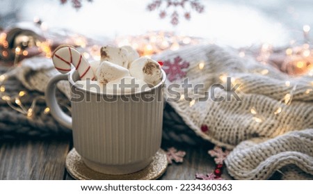 A cup of cocoa with marshmallows close-up on a blurred background.