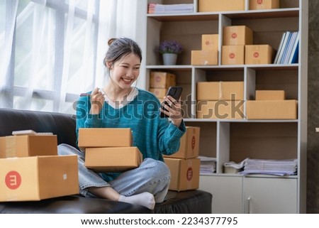 
Asian woman taking orders over the phone Online sales, delivery, marketing. Excited young Asian entrepreneurs with digital laptops while working from home. Small business Startup SME