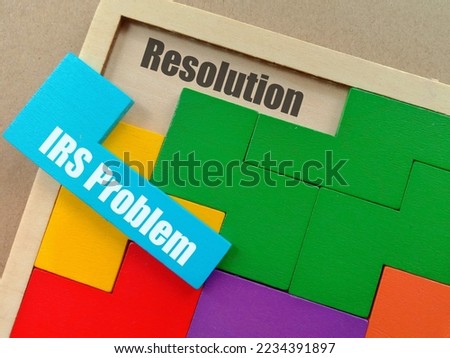 Business Concept - IRS Problem text at blue puzzle and Resolution text at space of wooden puzzle isolated brown background 