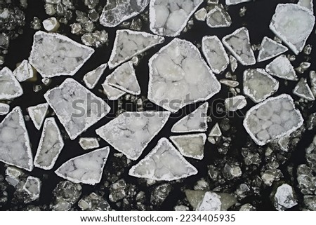 Aerial view of floating ice floes in the lake against the backdrop of black water in winter. View down, northern abstraction Royalty-Free Stock Photo #2234405935