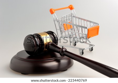Hammer of judge and pushcart on gray background Royalty-Free Stock Photo #223440769