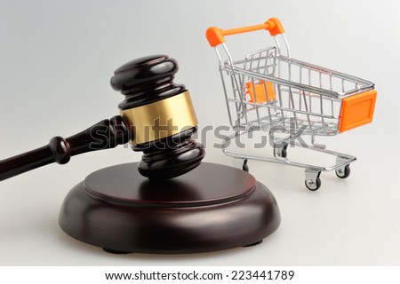 Hammer of judge and pushcart on gray background Royalty-Free Stock Photo #223441789