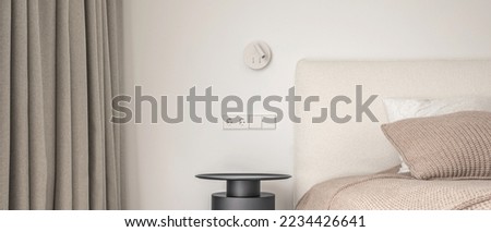 White wall lamp above the bed, metal beside table, white electrical outlet, oak wooden floor.
Modern minimalist aesthetic bedroom interior design in warm shades Royalty-Free Stock Photo #2234426641