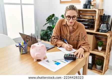 Young blonde woman working at office