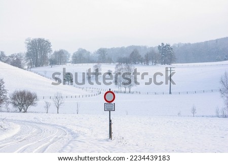 Snow-covered hill country, which serves as pasture in summer and is fronted by the German sign no. 250 "Traffic prohibited for vehicles of all kinds", makes a beautiful winter landscape.