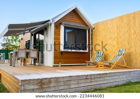small wooden cabin house. tiny house and garden with two sun loungers. luxury camping, glamping Royalty-Free Stock Photo #2234446081