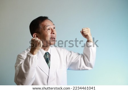 Middle-aged Asian doctor in a white coat on blue background. Concept image of regenerative medicine, vaccine development and advanced therapy.