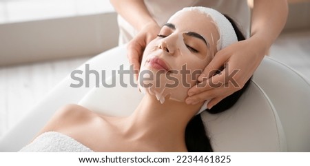 Cosmetologist applying mask onto woman's face in beauty salon Royalty-Free Stock Photo #2234461825