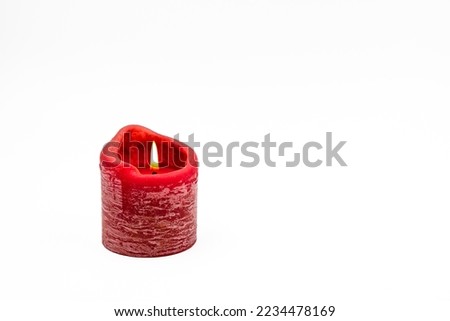 A red burning candle isolated on white background as Christmas card