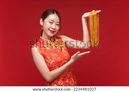 Young asian woman wearing qipao cheongsam dress with gold necklaces on red background for Chinese new year festival Royalty-Free Stock Photo #2234481027