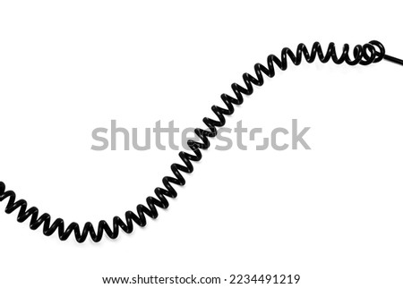 Twisted black telephone cord on a white background.Black telephone wire. Royalty-Free Stock Photo #2234491219