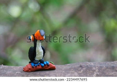A toy toucan with an orange beak close-up. Tropical birds.