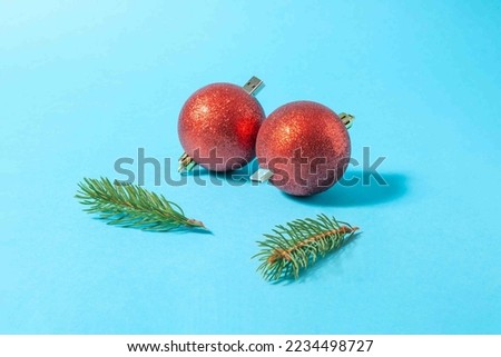 Creative composition made of red Christmas baubles with usb connector and green fir branches on pastel blue background. Holiday memories concept.