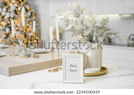 Portrait white picture frame mockup with christmas gifts, boken lights . High quality photo