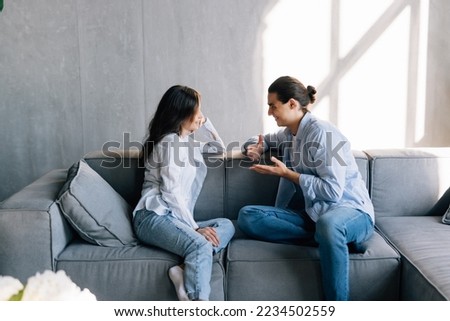 Man and young woman sitting on a couch and talk.