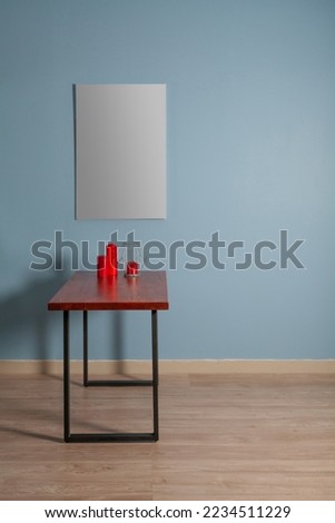 White canvas for painting on a wooden table against a blue wall in the interior mockap