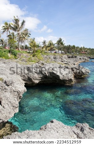 The turquoise color waters and eroded rocky shore in Tadine village on Mare island (New Caledonia). Royalty-Free Stock Photo #2234512959