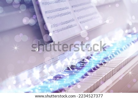 Glowing fairy lights on piano, closeup. Christmas music. Bokeh effect