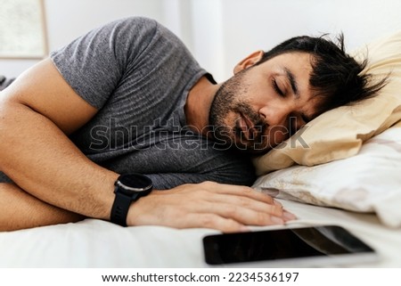 Man with smart watch sleeping in bed at home Royalty-Free Stock Photo #2234536197