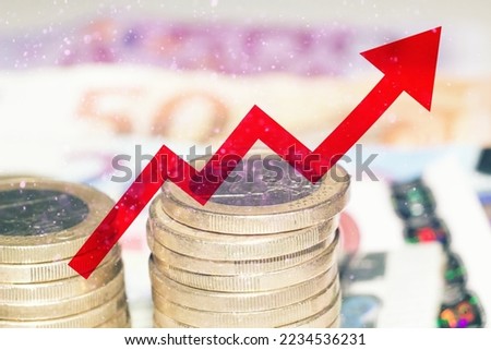 Red arrow over banknotes and euro coins, concept of increase of cost of living. 