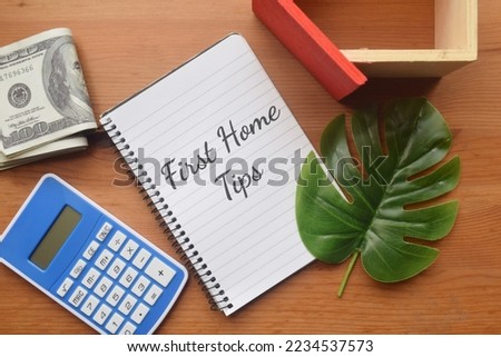 First Home Tips wording with calculator,mini house and money. Property concept  Royalty-Free Stock Photo #2234537573
