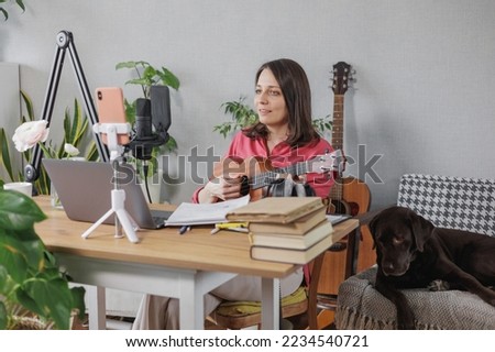 soft selective focus, female musician and podcaster creates audio and video content for social media. a confident European woman speaks into a microphone. streaming and working online on the internet