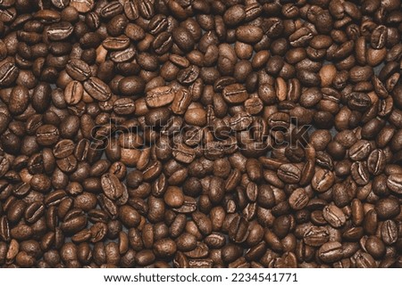 Texture of roasted aromatic brown coffee beans, place for writing and copy space.