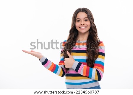 Teenager child pointing to the side with a finger to present a product or idea. Teen girl in casual outfit pointing empty space. Happy girl face, positive and smiling emotions.